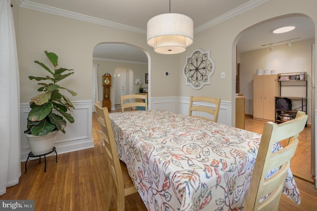 416 Copley Rd, Haddonfield, NJ 08033 - dining room featuring wood finished floors, arched walkways, track lighting, wainscoting, and crown molding