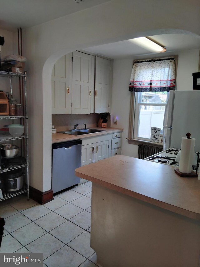 221 Princess St, Hanover, PA 17331 - kitchen with dishwasher, freestanding refrigerator, arched walkways, white cabinets, and light tile patterned floors