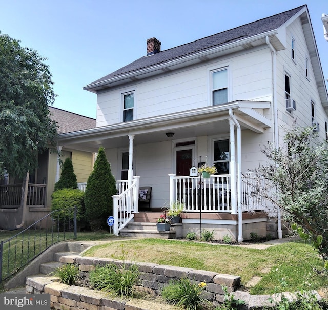 221 Princess St, Hanover, PA 17331 - view of front facade featuring covered porch, a chimney, cooling unit, roof with shingles, and a front yard