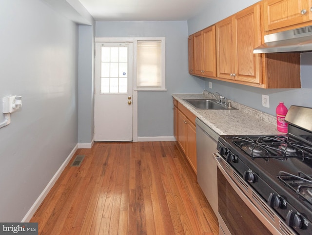 4917 Pembridge Ave, Baltimore, MD 21215 - kitchen featuring appliances with stainless steel finishes, under cabinet range hood, light countertops, and light wood finished floors