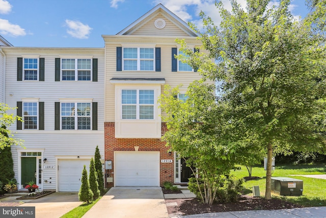12814 Sutherby Ln, Germantown, MD 20874 - townhome / multi-family property with concrete driveway, an attached garage, and brick siding