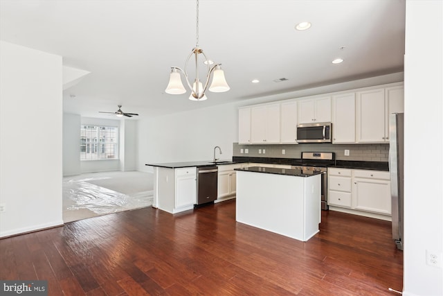 12814 Sutherby Ln, Germantown, MD 20874 - kitchen featuring stainless steel appliances, a peninsula, dark countertops, white cabinetry, and recessed lighting