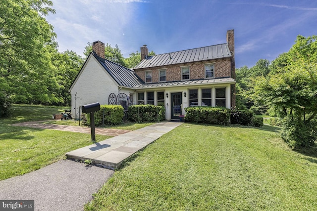 7901 Warfield Rd, Gaithersburg, MD 20882 - view of front of home with a standing seam roof, a chimney, a front lawn, and a metal roof