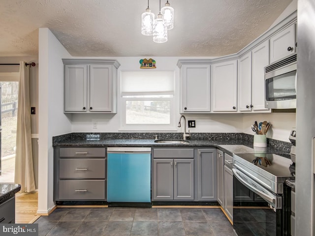 9907 Treetop Ln, Lanham, MD 20706 - kitchen featuring appliances with stainless steel finishes, gray cabinets, a textured ceiling, a chandelier, and dark stone counters