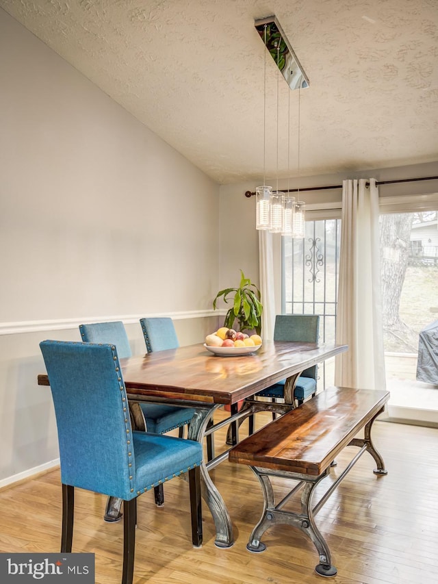9907 Treetop Ln, Lanham, MD 20706 - dining room with a textured ceiling and light wood-style flooring
