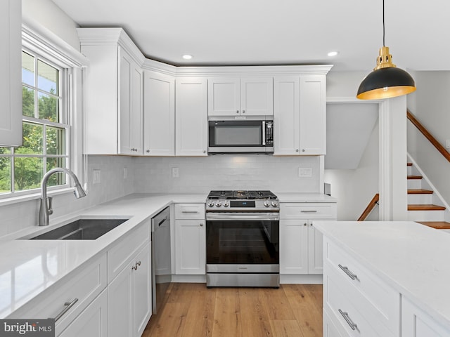 357 Avis Mill Rd, Pilesgrove, NJ 08098 - kitchen with appliances with stainless steel finishes, light countertops, white cabinets, tasteful backsplash, and light wood-style floors