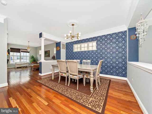 12404 Carriage Park Pl, Clarksburg, MD 20871 - dining space with wallpapered walls, a chandelier, wood finished floors, decorative columns, and crown molding