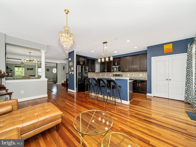 12404 Carriage Park Pl, Clarksburg, MD 20871 - living room featuring a chandelier, light wood-style floors, ornate columns, and recessed lighting