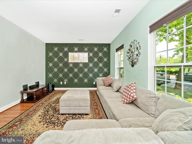 12404 Carriage Park Pl, Clarksburg, MD 20871 - living room with wood finished floors, an accent wall, and wallpapered walls