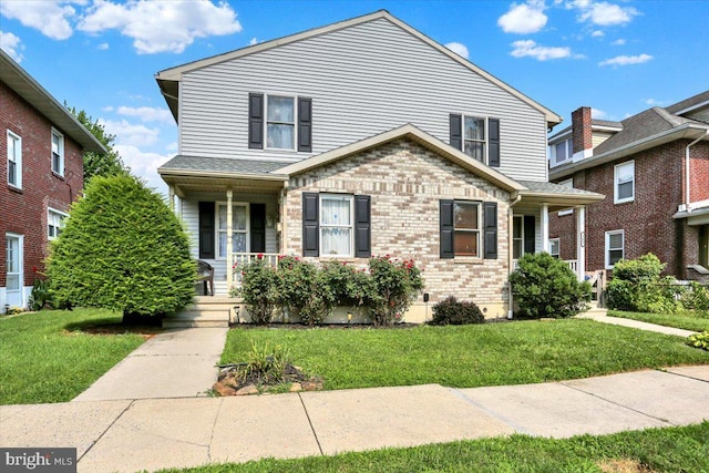 311 Woodside, West Lawn, PA 19609 - traditional-style house featuring a porch, a front yard, and brick siding