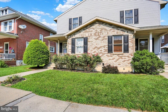 311 Woodside, West Lawn, PA 19609 - view of front facade with a porch, a front yard, and brick siding