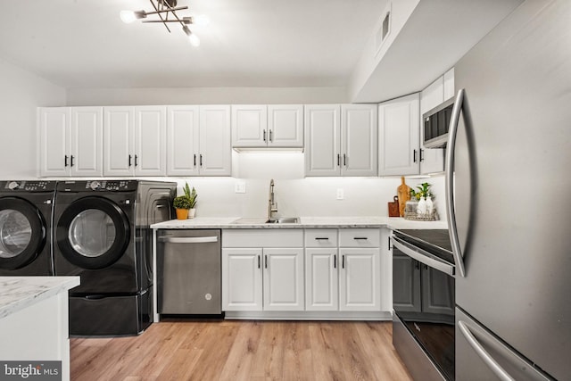 9733 Kings Crown Ct Unit 202, Fairfax, VA 22031 - laundry area featuring washing machine and clothes dryer, light wood-type flooring, and a chandelier