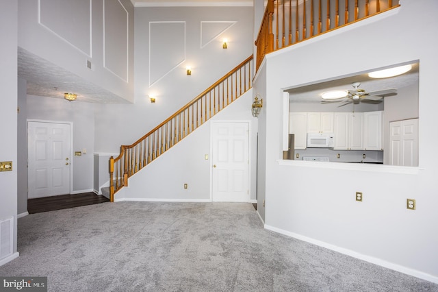 4938 Brightleaf Ct Unit 4938, Baltimore, MD 21237 - unfurnished living room with carpet flooring, stairway, ceiling fan, and a towering ceiling