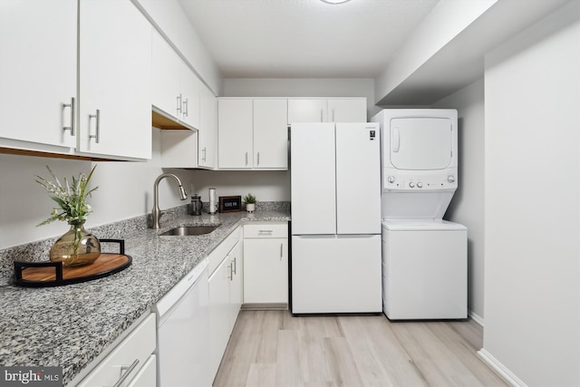 15115 Interlachen Dr Unit 3-415, Silver Spring, MD 20906 - washroom featuring estacked washer and dryer and light wood-style flooring