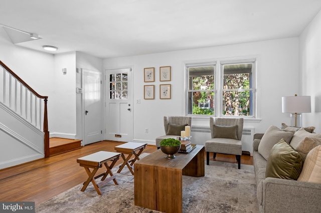3718 Yolando Rd, Baltimore, MD 21218 - living room with radiator, wood finished floors, and stairs