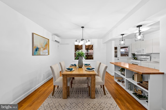 3718 Yolando Rd, Baltimore, MD 21218 - dining space featuring a chandelier, light wood-type flooring, and a wall unit AC
