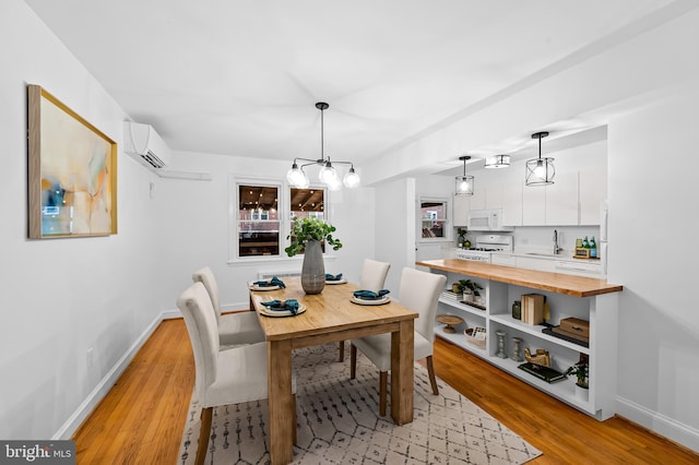 3718 Yolando Rd, Baltimore, MD 21218 - dining room featuring light wood finished floors, a chandelier, and a wall mounted AC