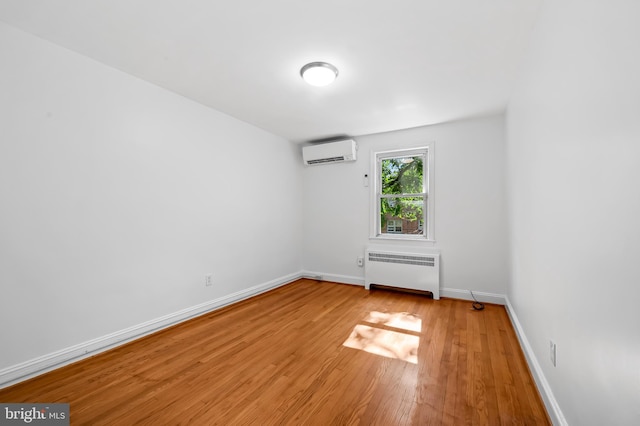 3718 Yolando Rd, Baltimore, MD 21218 - empty room with radiator heating unit, a wall unit AC, and light wood-style floors