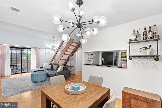 6900 Mary Caroline Cir Unit L, Alexandria, VA 22310 - dining space featuring a chandelier, stairs, and light wood finished floors