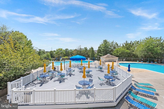 6900 Mary Caroline Cir Unit L, Alexandria, VA 22310 - community pool featuring a deck, view of scattered trees, and outdoor dining area