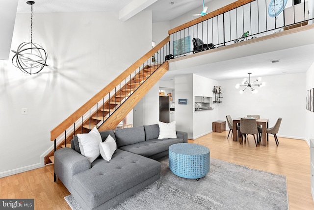6900 Mary Caroline Cir Unit L, Alexandria, VA 22310 - living room with a chandelier, wood finished floors, stairway, beam ceiling, and a high ceiling