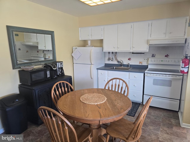 1203 Beach Ave E Unit 8, Brigantine, NJ 08203 - kitchen with white appliances, under cabinet range hood, dark countertops, and decorative backsplash