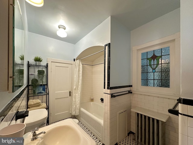 5512 Sefton Ave, Baltimore, MD 21214 - full bath featuring tile walls, shower / bathtub combination with curtain, wainscoting, tile patterned floors, and radiator