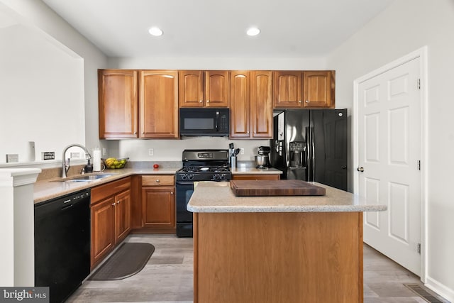 33 S Cummings Dr, Middletown, DE 19709 - kitchen featuring black appliances, a kitchen island, light countertops, light wood-style flooring, and recessed lighting