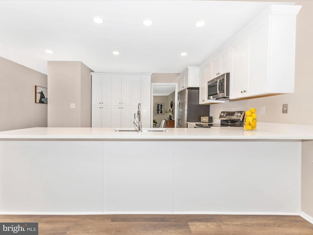 12004 Cheyenne Rd, Gaithersburg, MD 20878 - kitchen with appliances with stainless steel finishes, light countertops, white cabinetry, wood finished floors, and recessed lighting