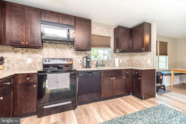 883 N Hanover St, Pottstown, PA 19464 - kitchen with black appliances, light wood-type flooring, light countertops, dark brown cabinets, and backsplash