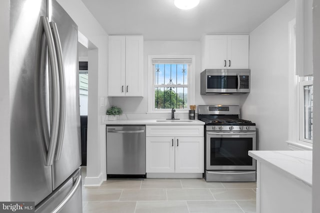 4621 A St SE, Washington, DC 20019 - kitchen with appliances with stainless steel finishes, white cabinets, light stone countertops, and light tile patterned flooring