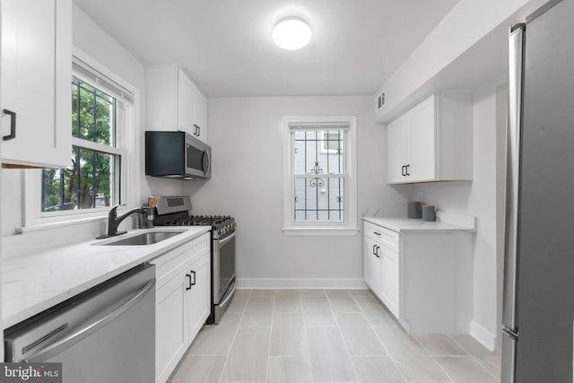 4621 A St SE, Washington, DC 20019 - kitchen with appliances with stainless steel finishes, white cabinetry, light stone counters, and light tile patterned flooring