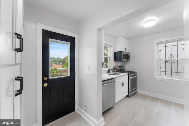 4621 A St SE, Washington, DC 20019 - kitchen featuring stainless steel appliances, white cabinetry, light countertops, and light tile patterned flooring