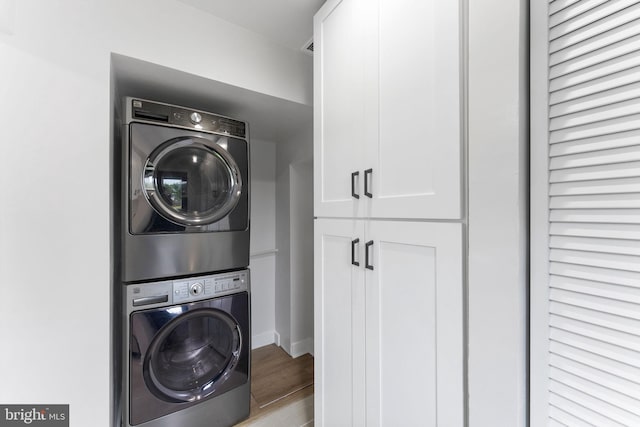 4621 A St SE, Washington, DC 20019 - laundry room featuring estacked washer and dryer, cabinet space, and wood finished floors