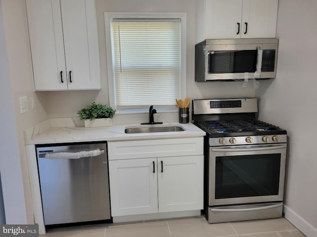 4621 A St SE, Washington, DC 20019 - kitchen featuring appliances with stainless steel finishes, white cabinetry, light stone counters, and light tile patterned floors