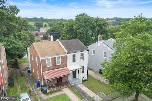 4621 A St SE, Washington, DC 20019 - view of front of home with brick siding, a chimney, a fenced backyard, and a shingled roof