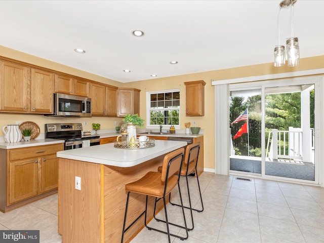 1402 Marian Way, Mount Airy, MD 21771 - kitchen with stainless steel appliances, light countertops, a breakfast bar, a kitchen island, and light tile patterned floors