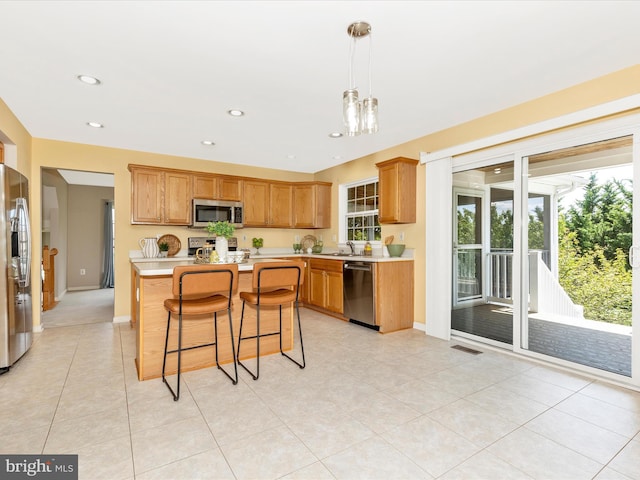 1402 Marian Way, Mount Airy, MD 21771 - kitchen featuring appliances with stainless steel finishes, light countertops, a kitchen bar, decorative light fixtures, and a center island