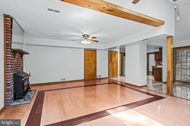 63 Lakeside Dr, Marlton, NJ 08053 - unfurnished living room with ceiling fan, a wood stove, and wood-type flooring