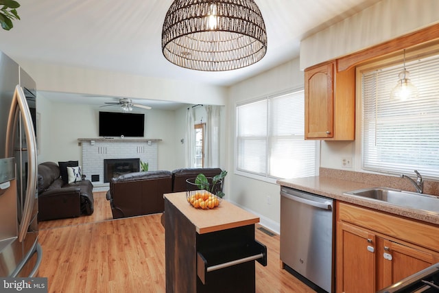 1618 Whitcomb Rd, Forked River, NJ 08731 - kitchen with stainless steel appliances, light wood finished floors, a ceiling fan, a fireplace, and light countertops