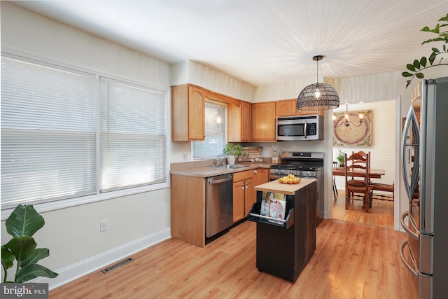 1618 Whitcomb Rd, Forked River, NJ 08731 - kitchen featuring appliances with stainless steel finishes, light countertops, a center island, and light wood-style flooring