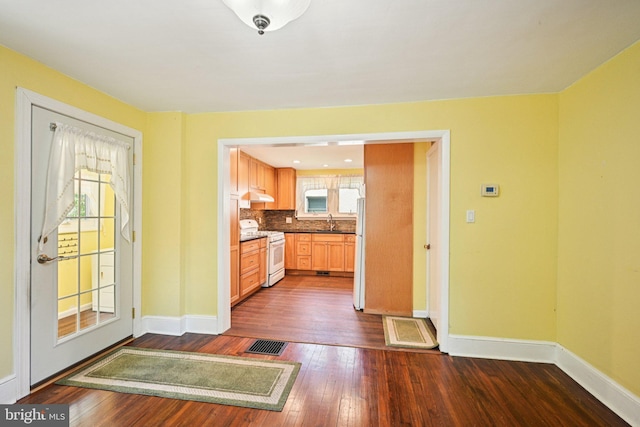 28 Oriole Ave, Media, PA 19063 - kitchen with white appliances, dark wood-style floors, under cabinet range hood, tasteful backsplash, and dark countertops