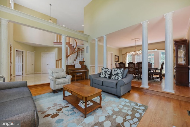 10009 Thompson Ridge Ct, Great Falls, VA 22066 - living area featuring decorative columns, wood finished floors, stairs, ornamental molding, and a chandelier
