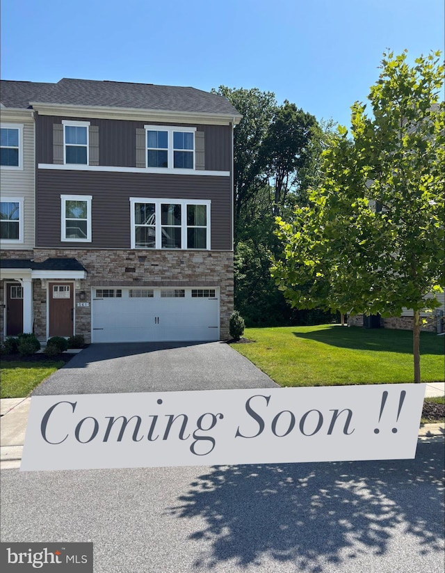 561 Katherine Ave, Baltimore, MD 21221 - view of front of property with stone siding, asphalt driveway, a garage, board and batten siding, and a front yard