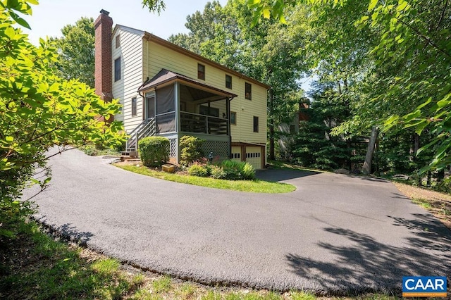 1754 Hearthglow Ln, Charlottesville, VA 22901 - view of front of home with a sunroom, a chimney, a garage, and driveway
