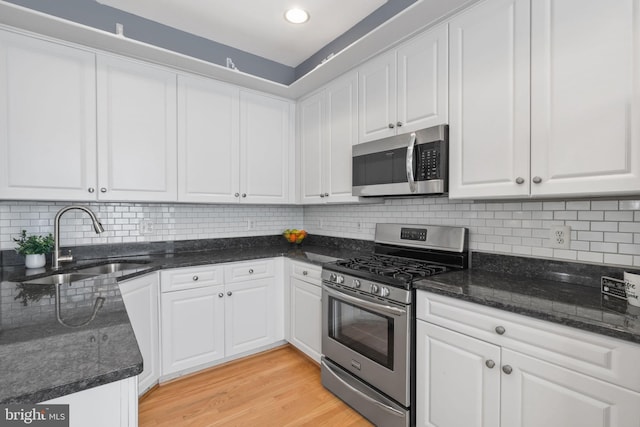 6038 Lincolnia Rd, Alexandria, VA 22312 - kitchen with stainless steel appliances, white cabinets, light wood finished floors, backsplash, and recessed lighting