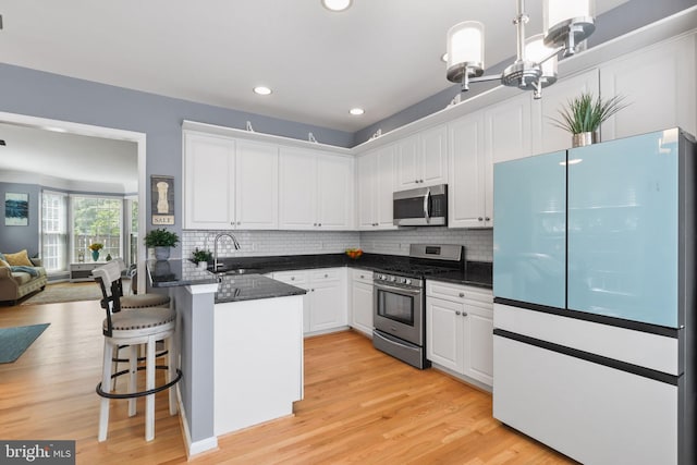 6038 Lincolnia Rd, Alexandria, VA 22312 - kitchen with stainless steel appliances, a peninsula, white cabinets, and recessed lighting
