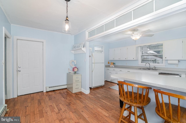 332 Old Stone House Rd S, Boiling Springs, PA 17007 - kitchen featuring freestanding refrigerator, baseboard heating, light countertops, white cabinets, and crown molding