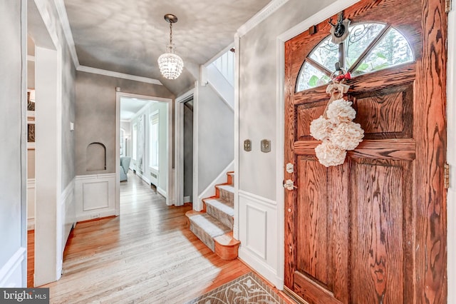 606 E Seminary Ave, Baltimore, MD 21286 - foyer entrance featuring light wood-type flooring, a chandelier, crown molding, stairway, and a wainscoted wall