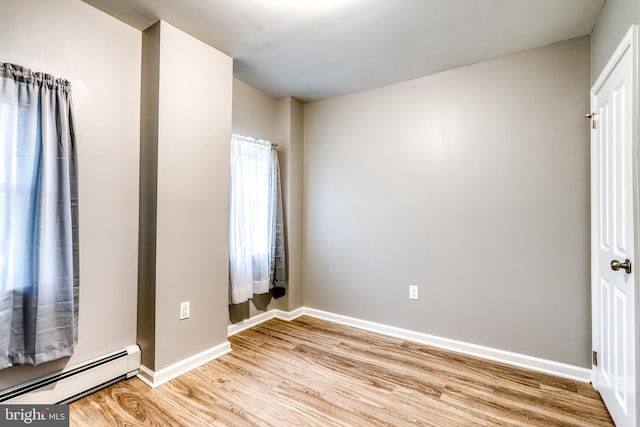 303 Lincoln Ave, Bristol, PA 19007 - unfurnished bedroom featuring a baseboard heating unit and light wood-style floors